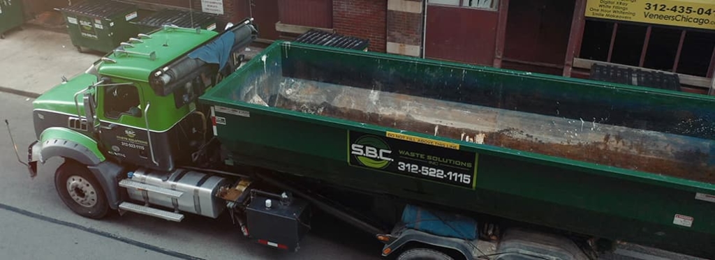 A roll-off dumpster with an open top, made of durable steel, designed for handling construction and renovation debris.